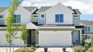 View of front of house featuring board and batten siding, driveway, and a shingled roof