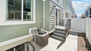 View of patio featuring a view of city, fence, and central AC unit