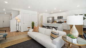 Living area with light wood-type flooring, recessed lighting, and baseboards