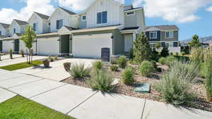 View of front of home with board and batten siding, a residential view, concrete driveway, and an attached garage