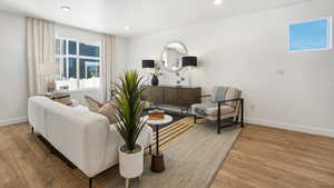 Living area with light wood-style floors, baseboards, and recessed lighting