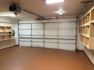 Garage with a garage door opener and baseboards