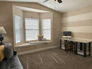 Office with dark colored carpet, ceiling fan, and baseboards