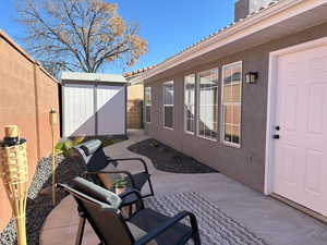 View of patio featuring a fenced backyard, an outdoor structure, and a storage shed