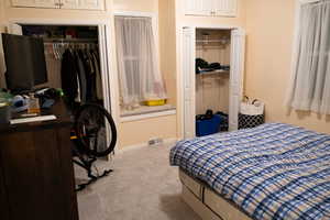 Carpeted bedroom featuring a closet