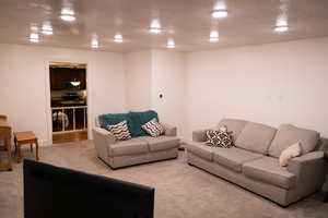 Living room with a textured ceiling and carpet flooring