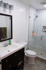 Bathroom with vanity, toilet, tile patterned floors, and walk in shower