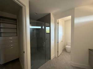 Bathroom featuring a shower stall, vanity, and marble finish flooring