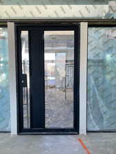 Doorway to outside with unfinished concrete flooring