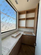 Kitchen with light countertops, open shelves, and dark wood finished floors