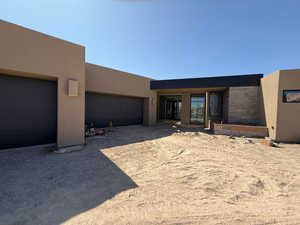 Pueblo-style house with stucco siding and a garage