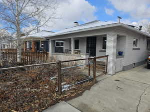 View of front of house featuring a fenced front yard, a porch, and brick siding