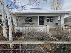 Bungalow with a fenced front yard, brick siding, and a porch