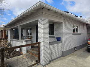 View of property exterior featuring covered porch and brick siding