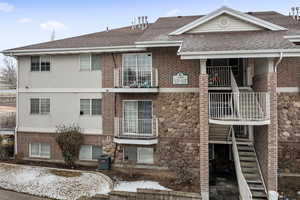 View of property with stairway and central AC unit