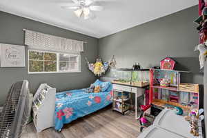 Bedroom with a textured ceiling, a ceiling fan, and wood finished floors