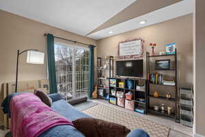 Living area featuring light wood finished floors, lofted ceiling, heating unit, a textured ceiling, and recessed lighting