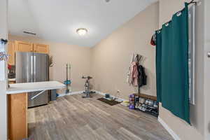 Interior space with light wood-style floors, light brown cabinets, light countertops, and freestanding refrigerator