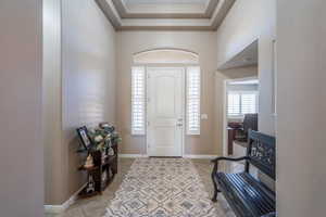 Entrance foyer with light tile patterned floors and baseboards