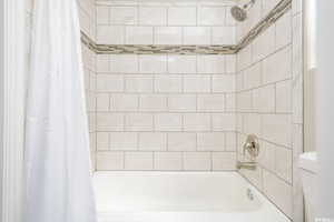 Bathroom featuring shower / bathtub combination with curtain