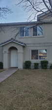 View of front of home with stucco siding and a front yard