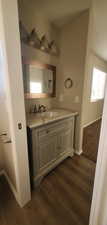 Bathroom with vanity, baseboards, and wood finished floors