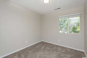 Unfurnished room with carpet floors, visible vents, and baseboards