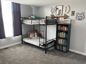 Carpeted bedroom featuring visible vents and baseboards