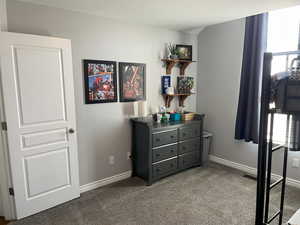 Bedroom with carpet, a textured ceiling, and baseboards