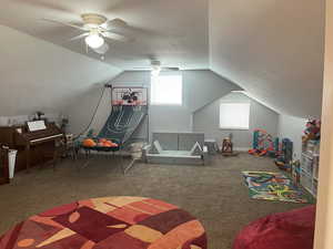 Game room featuring vaulted ceiling, carpet floors, a textured ceiling, and ceiling fan