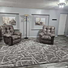 Interior space with dark wood-style flooring, visible vents, a textured ceiling, and baseboards