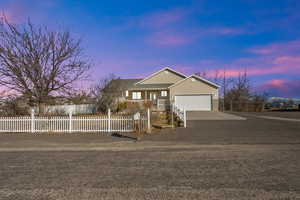 Ranch-style house with concrete driveway, brick siding, a fenced front yard, and attached garage