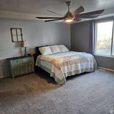 Bedroom featuring carpet, ceiling fan, a textured ceiling, and baseboards