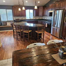 Kitchen featuring a breakfast bar, freestanding refrigerator, black range with gas cooktop, a sink, and a kitchen island