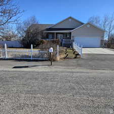 Single story home featuring a fenced front yard, concrete driveway, and a garage