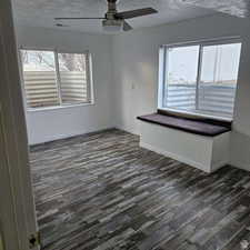 Spare room featuring dark wood-style flooring, visible vents, ceiling fan, a textured ceiling, and baseboards