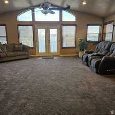 Living area with lofted ceiling, a ceiling fan, carpet flooring, and recessed lighting