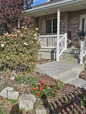 View of exterior entry featuring brick siding