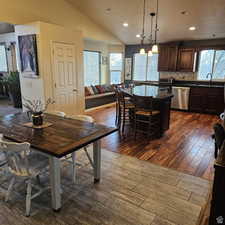 Dining area featuring vaulted ceiling, dark wood finished floors, and recessed lighting