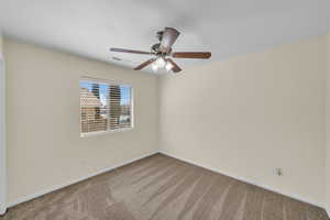 Carpeted spare room with a ceiling fan, visible vents, and baseboards