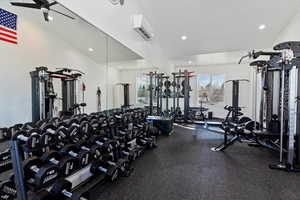 Exercise room with lofted ceiling, recessed lighting, and a wall mounted AC