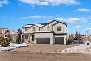 Modern inspired farmhouse featuring a standing seam roof, metal roof, board and batten siding, and an attached garage