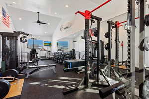 Gym with recessed lighting, vaulted ceiling, a ceiling fan, and an AC wall unit