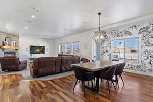 Dining space featuring a large fireplace, plenty of natural light, dark wood-type flooring, and recessed lighting