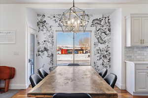 Dining space with a chandelier, light wood-style flooring, and baseboards