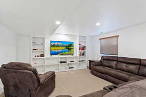 Living area with built in features, carpet, and recessed lighting