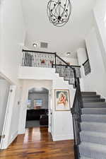 Stairs with baseboards, visible vents, and wood finished floors