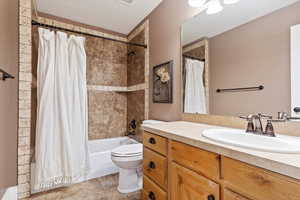 Bathroom with shower / tub combo, tile patterned flooring, vanity, and toilet