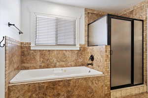 Full bathroom with a garden tub and a shower stall