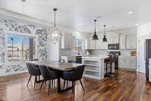 Dining space with dark wood-type flooring, recessed lighting, and baseboards